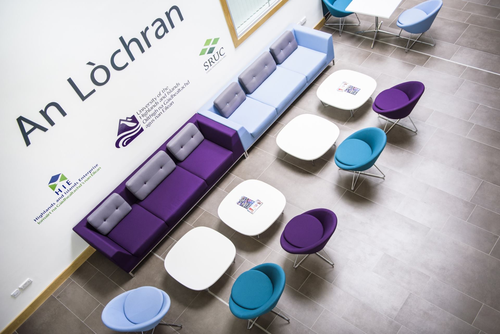 View from balcony looking down on tables and chairs in An Lochran, HIE's headquarters in Inverness